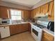 Bright kitchen featuring wood cabinets, gas range, microwave, and dishwasher at 1082 Sunshine Sw Way, Winter Haven, FL 33880