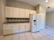 Kitchen features white cabinets and a refrigerator at 1136 Bell Tower W Xing, Kissimmee, FL 34759