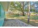 Backyard patio with mature trees and grassy area at 118 Whittier Ln, Winter Haven, FL 33884