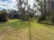 Large grassy backyard with trees and vegetation at 1322 Shady Cove W Rd, Haines City, FL 33844