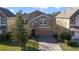 Two-story house with a tan exterior, stone accents, and a paved driveway at 137 Drayton Ave, Davenport, FL 33837