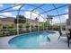 Inviting kidney-shaped pool with screened enclosure and patio furniture at 1591 Forest Hills Ln, Haines City, FL 33844