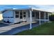 Mobile home with carport and partially visible screened patio at 161 Bonnie Dr, Auburndale, FL 33823