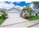 Light blue house with white garage door, neatly landscaped yard, and a paved driveway at 2060 Hemingway Ave, Haines City, FL 33844