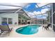 Inviting screened pool and spa with plenty of lounge chairs and a view of the backyard at 2060 Hemingway Ave, Haines City, FL 33844