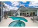 Screened pool and spa with patio furniture, a dining table, and serene backyard view at 2060 Hemingway Ave, Haines City, FL 33844