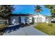 Newly renovated home exterior with gray driveway and green landscaping at 315 Lauderdale Ct, Kissimmee, FL 34759