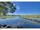 Tranquil lake view with lush vegetation and a wooden dock at 418 Orange Blossom Dr # 19, Winter Haven, FL 33880