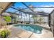 Relaxing kidney-shaped pool with a screened enclosure and landscaping at 5808 Driftwood Dr, Winter Haven, FL 33884