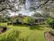 Spacious backyard with lush landscaping and screened patio at 1072 Old Cutler Rd, Lake Wales, FL 33898