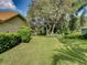 Side yard with mature trees and lush landscaping at 1072 Old Cutler Rd, Lake Wales, FL 33898