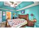 Main bedroom with teal walls and a wooden bed frame at 135 Mi Rancho Rd, Davenport, FL 33837