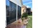 Landscaped area with a screened patio and wind sculptures at 1402 Colonial Ct, Winter Haven, FL 33884