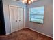 Bedroom with double closet doors, window, ceiling fan, and carpeted floors at 16 Kendra Ct # 16, Winter Haven, FL 33880