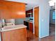 Kitchen with wood cabinets, double sink, and doorway to another room at 16 Kendra Ct # 16, Winter Haven, FL 33880
