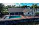 Elevated view of a backyard oasis featuring pool, screen enclosure, and lush greenery at 218 College Grove Ne Cir, Winter Haven, FL 33881