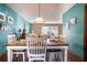 Dining room with white furniture, wood floors, teal walls, and natural light at 218 College Grove Ne Cir, Winter Haven, FL 33881