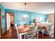 Dining area with a white table and chairs, teal walls, and hardwood floors at 218 College Grove Ne Cir, Winter Haven, FL 33881