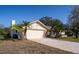 Exterior view of a home with a two-car garage, palm trees, and landscaped front yard at 218 College Grove Ne Cir, Winter Haven, FL 33881