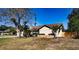 Front yard with trees, landscaping, and a stone retaining wall around the home at 218 College Grove Ne Cir, Winter Haven, FL 33881