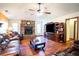 Living room with stone fireplace, wood floors, brown leather furniture, and ceiling fan at 218 College Grove Ne Cir, Winter Haven, FL 33881