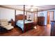 Spacious main bedroom with wooden four-poster bed, recliner, and ensuite bathroom access at 218 College Grove Ne Cir, Winter Haven, FL 33881