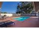 In-ground pool surrounded by a paved deck with lounge chairs and a dining table at 218 College Grove Ne Cir, Winter Haven, FL 33881