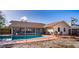 In-ground pool with screened enclosure, patio furniture, and basketball hoop at 218 College Grove Ne Cir, Winter Haven, FL 33881