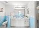 Clean bathroom with double sinks, light blue walls, and white cabinetry at 221 Prather Dr, Davenport, FL 33837