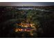 Night-time aerial view of a luxurious home with a pool, surrounded by lush landscaping and a lake at 2300 N Scenic Hwy # 104, Lake Wales, FL 33898