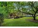 Green backyard with mature trees and a view of the house and pool at 2300 N Scenic Hwy # 104, Lake Wales, FL 33898
