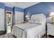 Blue walls and white bedding highlight this comfortable bedroom with an adjacent bathroom at 2300 N Scenic Hwy # 104, Lake Wales, FL 33898