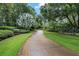 Long brick driveway lined with lush landscaping leading to a home entrance at 2300 N Scenic Hwy # 104, Lake Wales, FL 33898