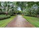 A curving brick driveway with manicured landscaping leads to a home's entrance at 2300 N Scenic Hwy # 104, Lake Wales, FL 33898
