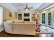 Gathering room with curved sofa, built-in shelving, fireplace, and access to backyard at 2300 N Scenic Hwy # 104, Lake Wales, FL 33898
