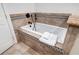 White jacuzzi tub with granite surround and tile detail at 2300 N Scenic Hwy # 104, Lake Wales, FL 33898