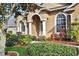 Tan house with arched entryway, white columns, and manicured landscaping at 231 Terranova Blvd, Winter Haven, FL 33884