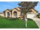 One-story house with tan exterior, arched entryway, and landscaped lawn at 231 Terranova Blvd, Winter Haven, FL 33884