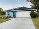 Newly built home with solar panels, landscaped yard, and two-car garage at 707 E Frederick Ave, Dundee, FL 33838