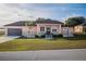 One-story home with peach siding, dark brown garage door, and landscaping at 8243 Alturas Rd, Bartow, FL 33830