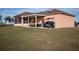 Home with covered patio, golf cart, and expansive lawn at 8243 Alturas Rd, Bartow, FL 33830