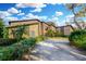 Front exterior of a brick home with a driveway lined with lush landscaping at 9 Skidmore Rd, Winter Haven, FL 33884