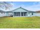 House back view with screened porch and fenced backyard at 910 Nancy Ct, Kissimmee, FL 34759