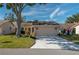 Tan single-story home with attached garage and mature landscaping at 3909 Cypress E Lndg, Winter Haven, FL 33884