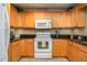 Bright kitchen with light wood cabinets, granite countertops, and white appliances at 3909 Cypress E Lndg, Winter Haven, FL 33884