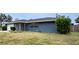 Newly painted blue house with white garage door and landscaping at 1001 Mockingbird Cir, Winter Haven, FL 33884