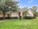 Tan house with a walkway leading to the front door, surrounded by lush green landscaping at 1099 Tequesta Trl, Lake Wales, FL 33898