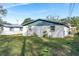 Back of house, light colored with blue trim, and a grassy yard at 1244 W 9Th St, Lakeland, FL 33805