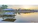 Sunset view of a boat parked at a dock with a covered boathouse at 1769 S Lake Reedy Blvd, Frostproof, FL 33843