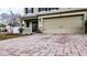 Tan two-car garage with paver driveway and stone accents at 2002 Honeybell Ave, Haines City, FL 33844